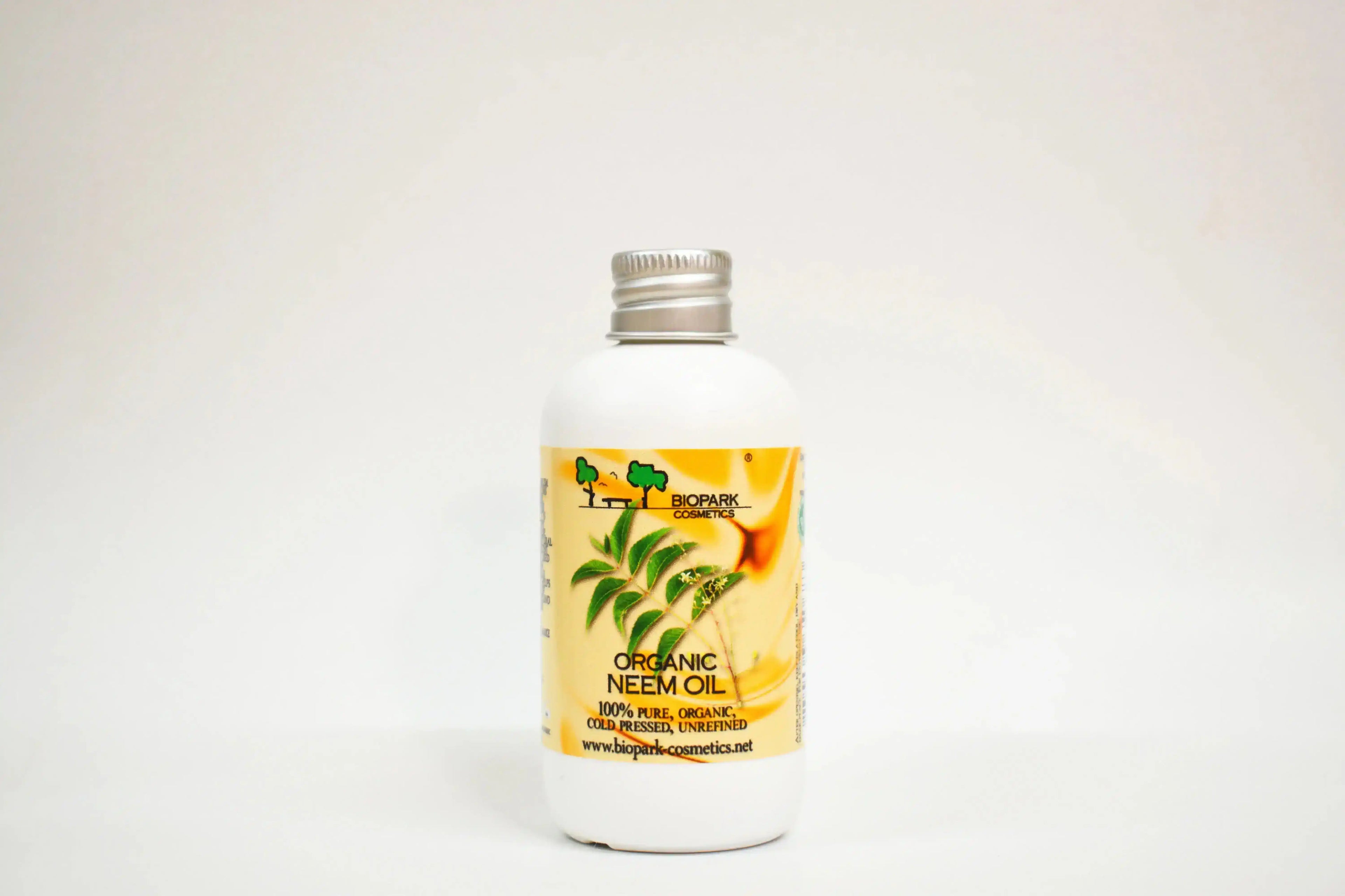 Bote de aceite de neem orgánico con una etiqueta visible sobre fondo blanco