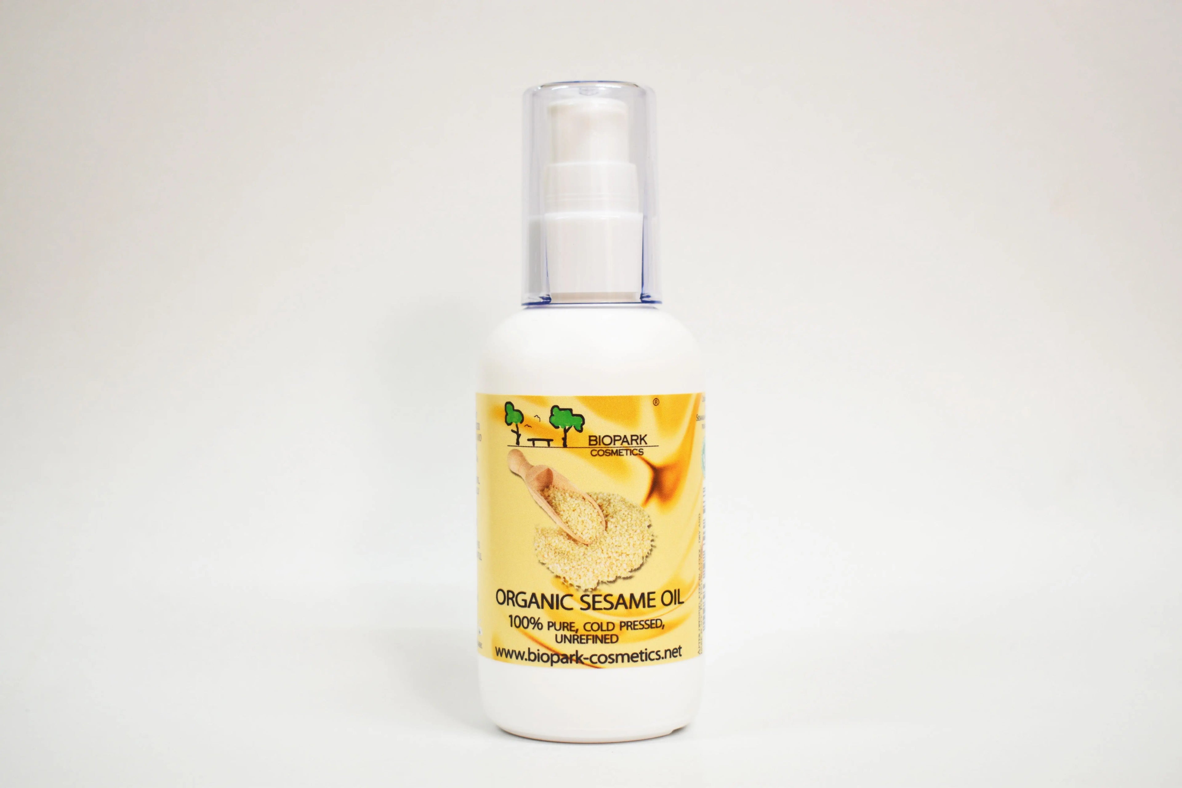 Bottle of organic sesame oil with a yellow label on a white background