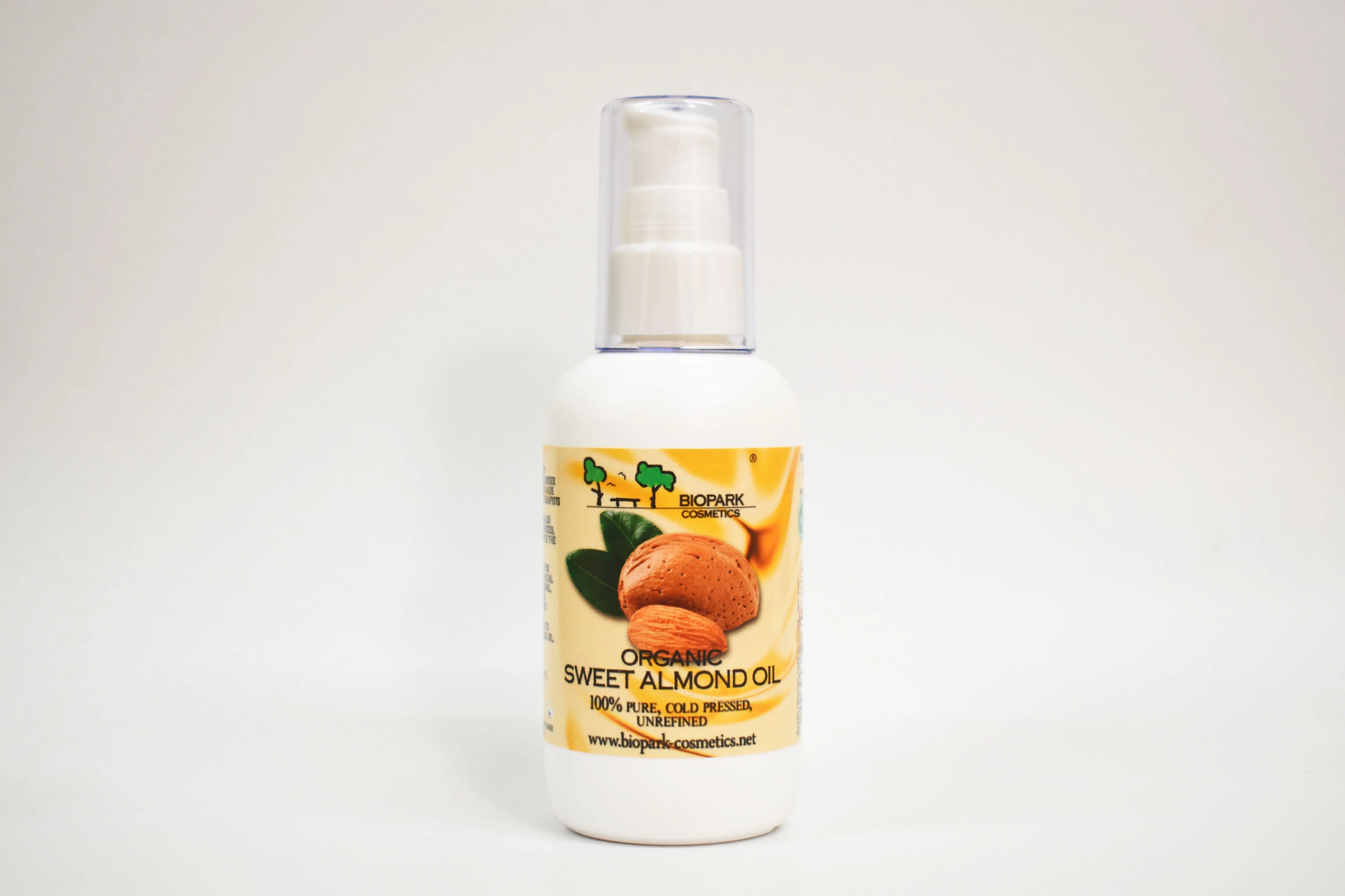 Bottle of organic sweet almond oil with a label on a white background