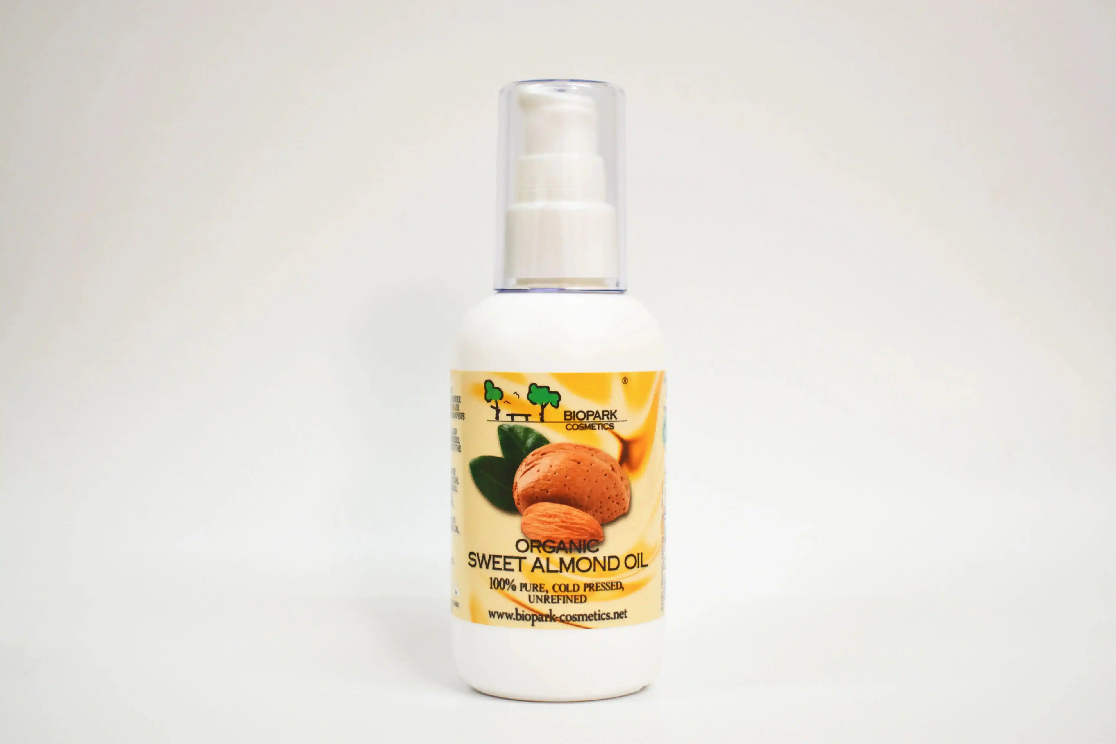 Botella de aceite de almendra dulce orgánico con una etiqueta sobre fondo blanco
