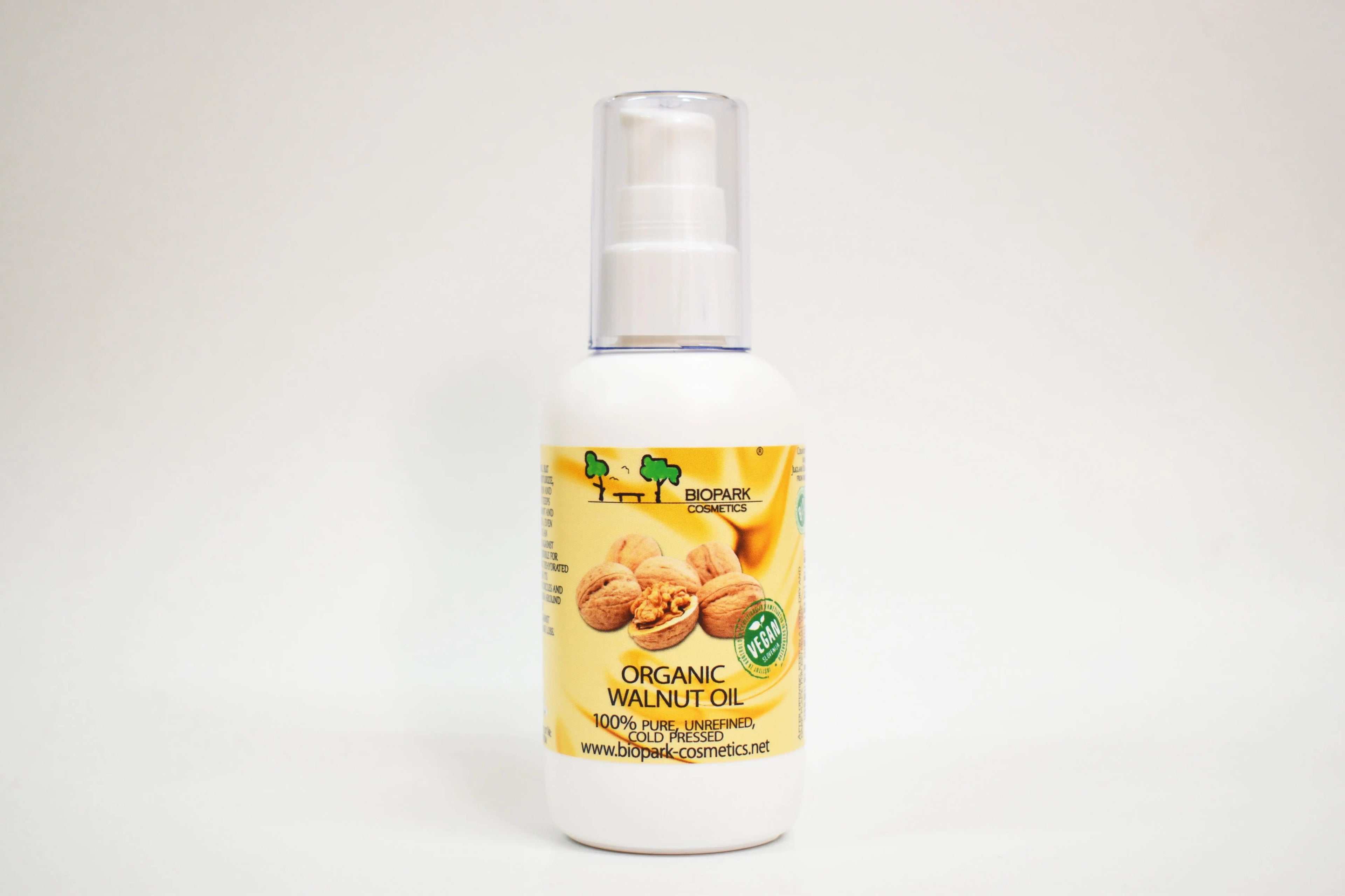 Bottle of organic walnut oil with a yellow label on a white background
