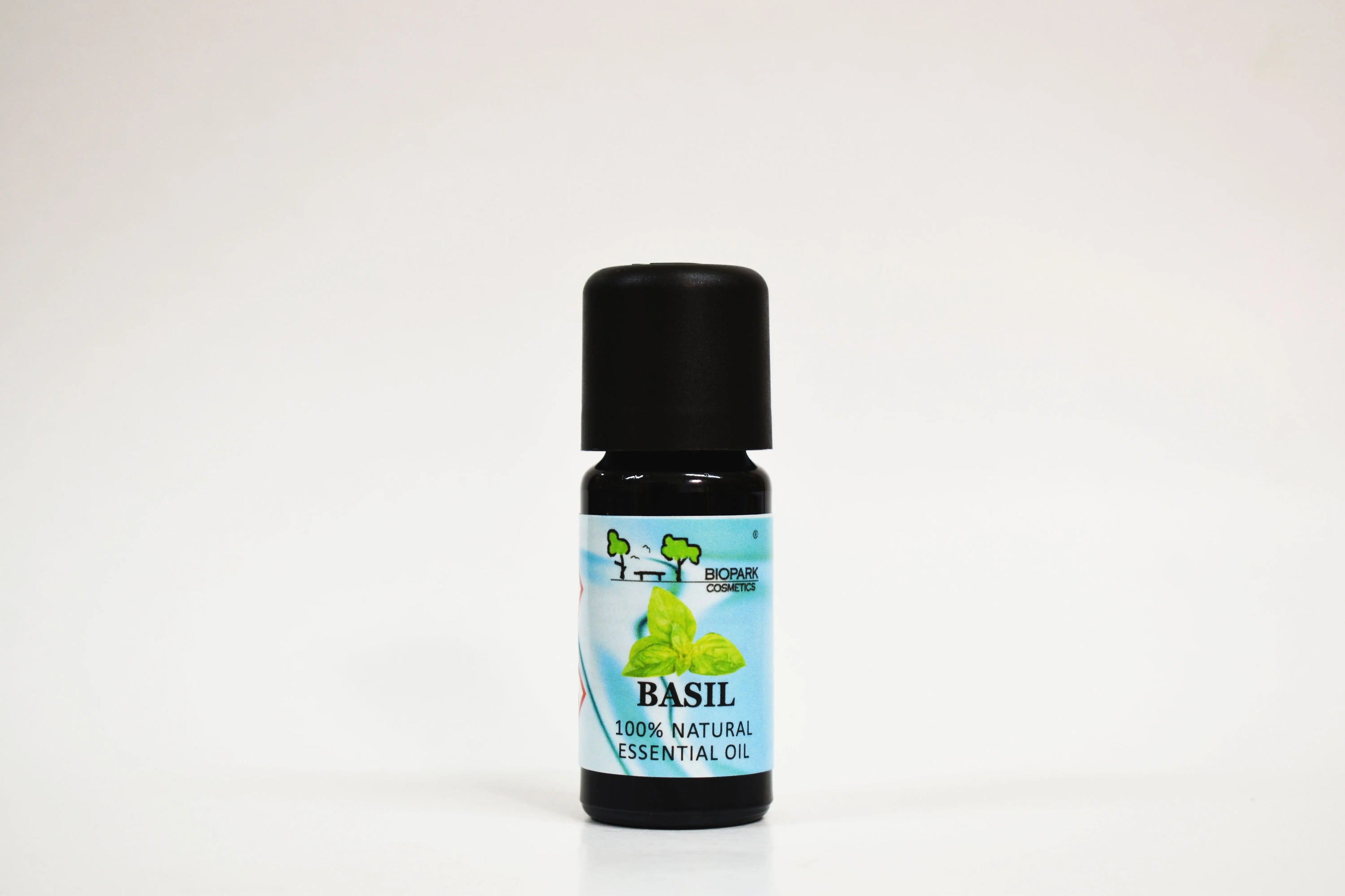 Bottle of basil essential oil on a white background