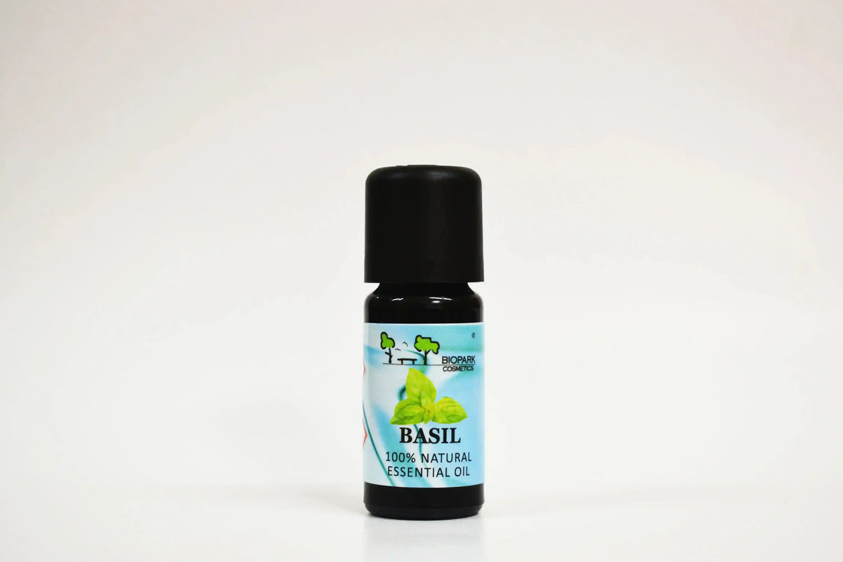 Bote de aceite esencial de albahaca sobre fondo blanco