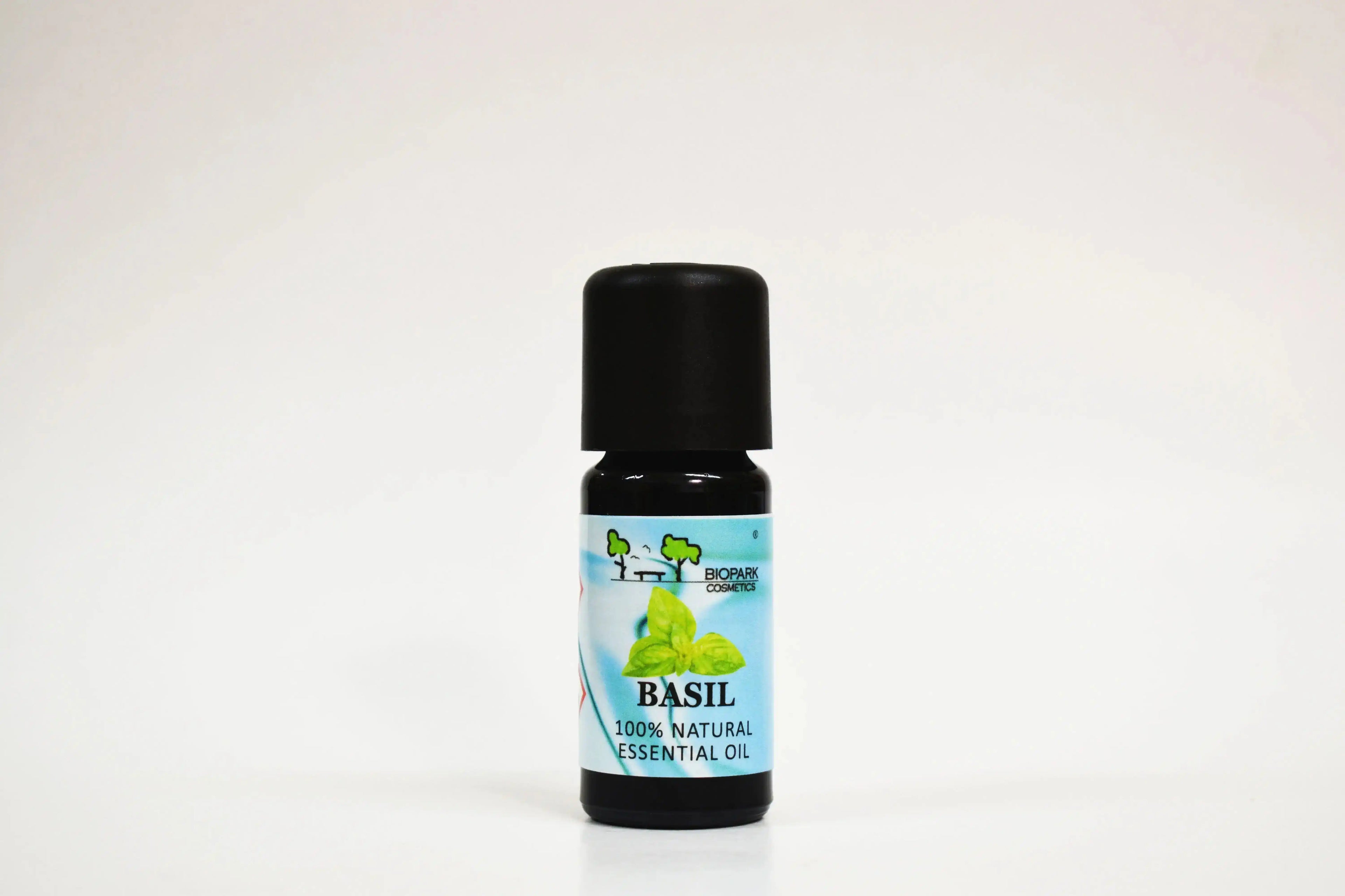 Bottle of basil essential oil on a white background