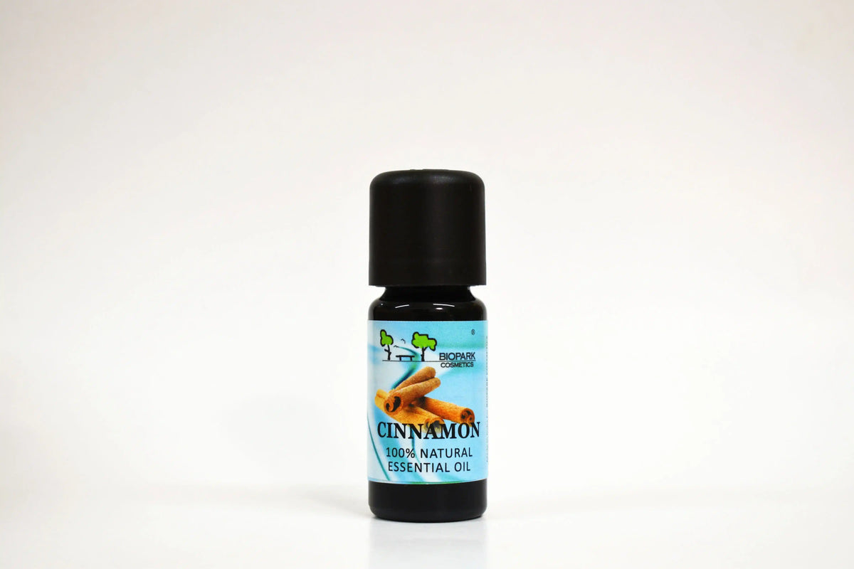 Botella de aceite esencial de canela sobre fondo blanco