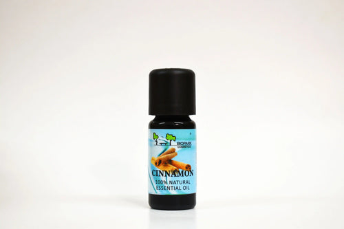 Botella de aceite esencial de canela sobre fondo blanco