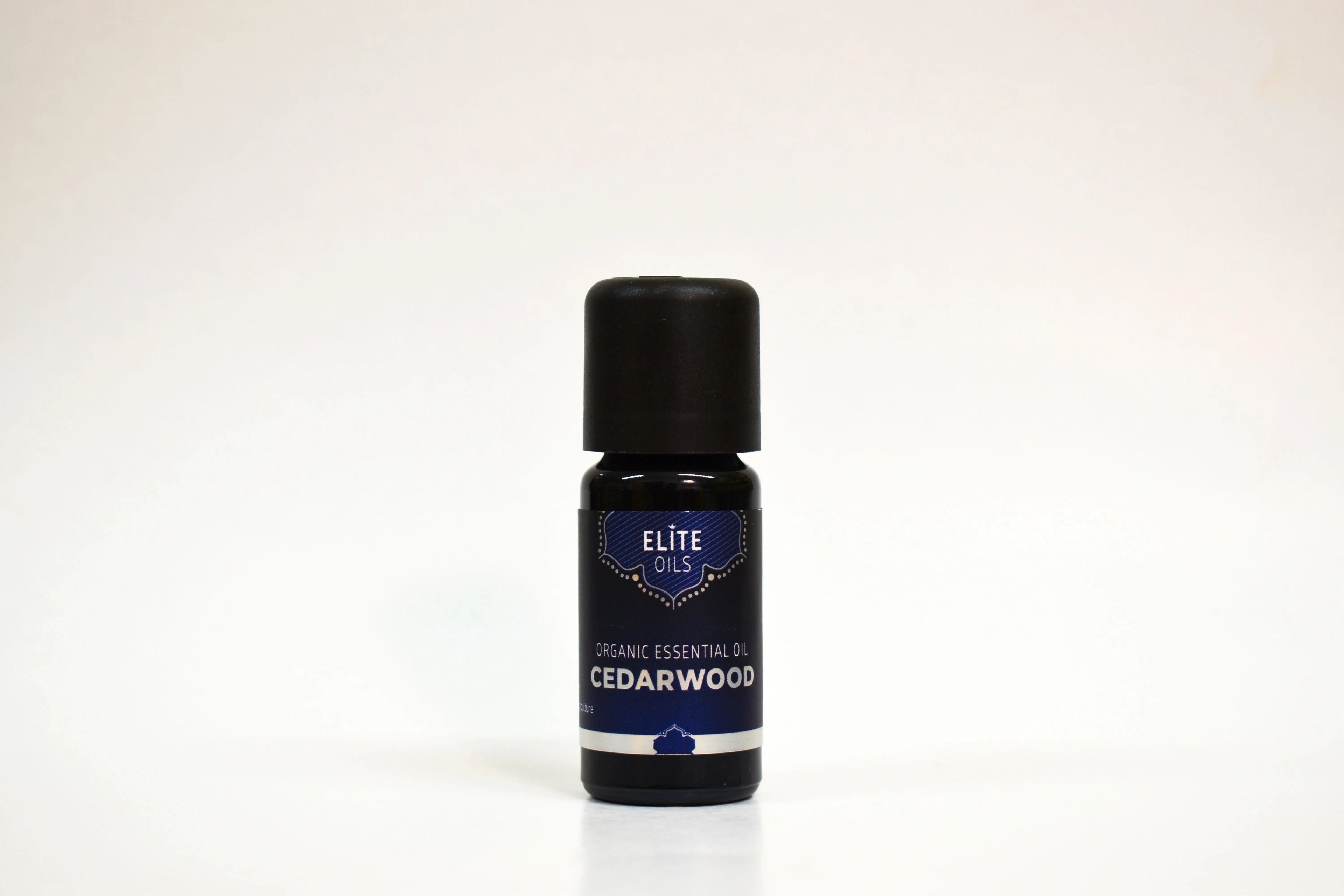 Bottle of Elite Oils Cedarwood essential oil on a white background