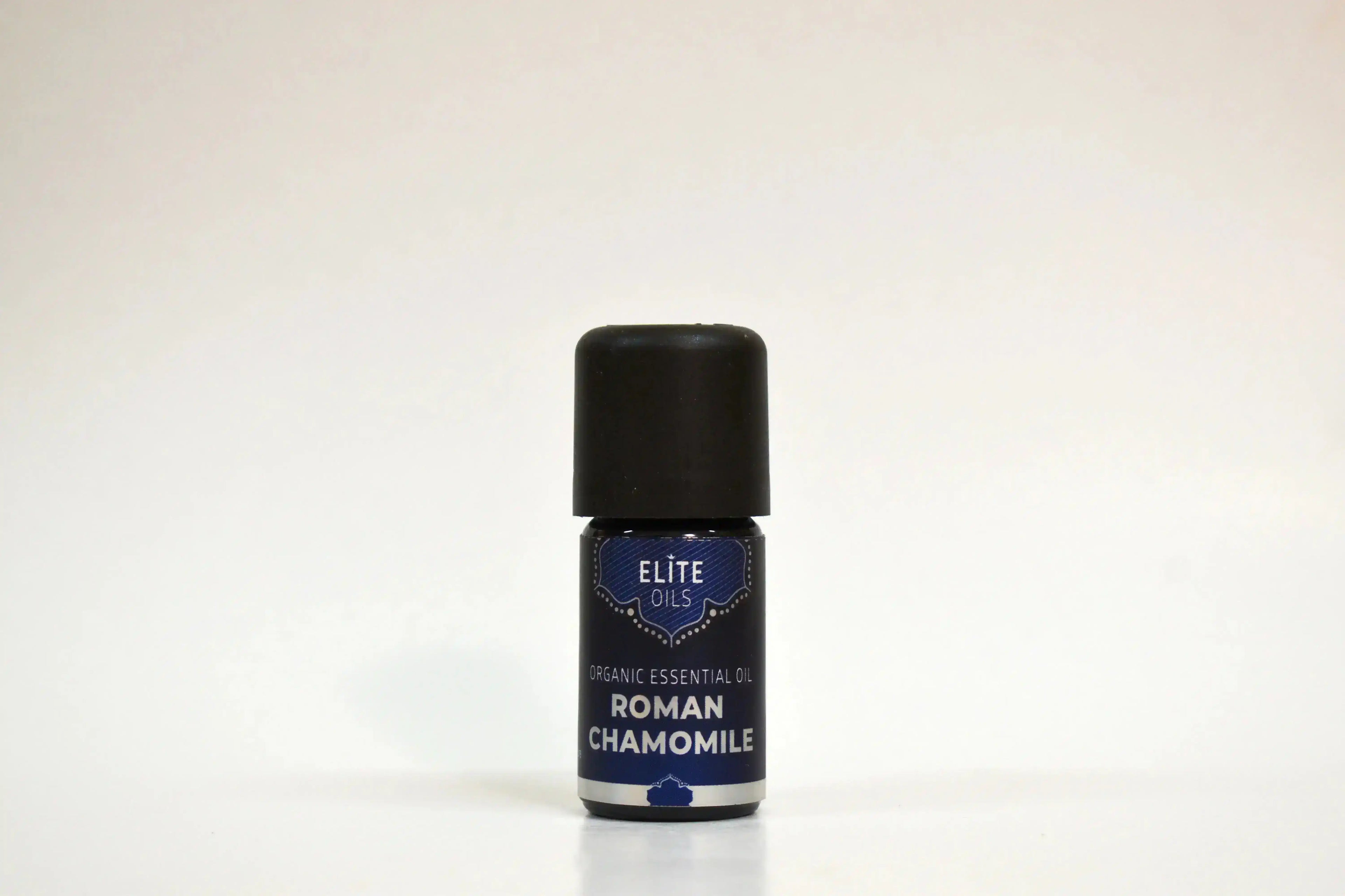 Bote de aceite esencial de manzanilla romana de Elite Oils sobre fondo blanco