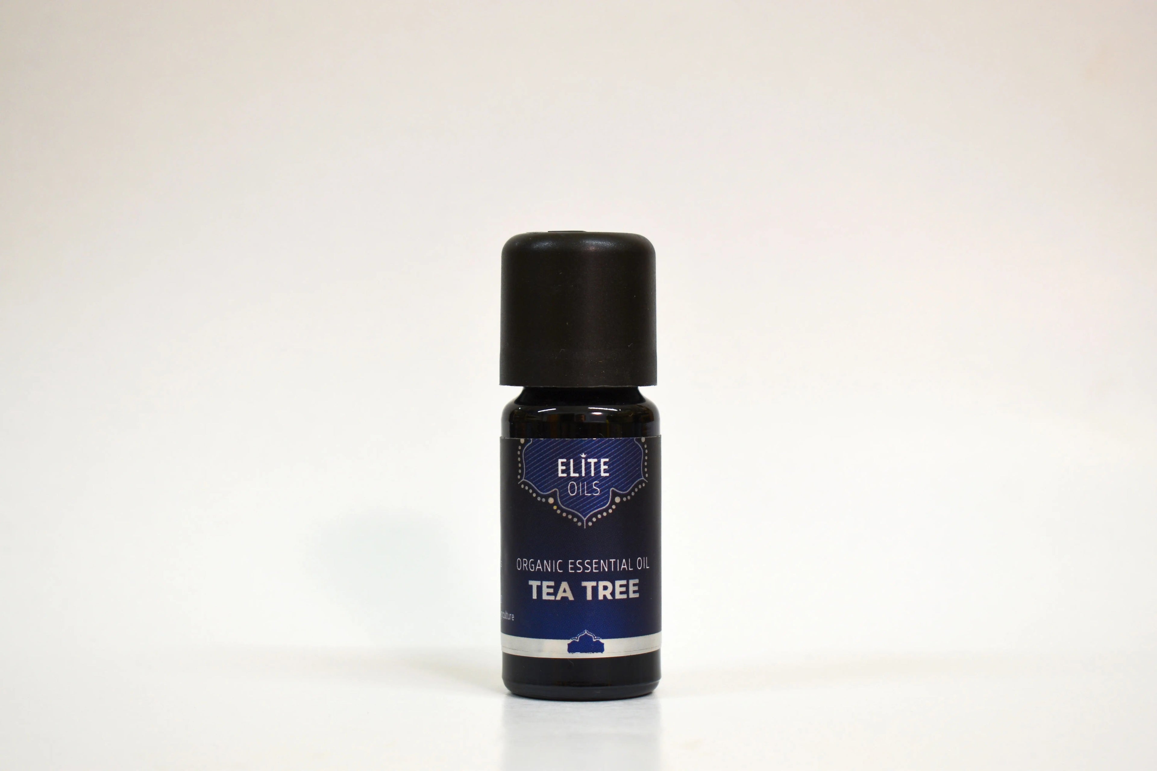 Bottle of Elite Oils Tea Tree essential oil on a white background