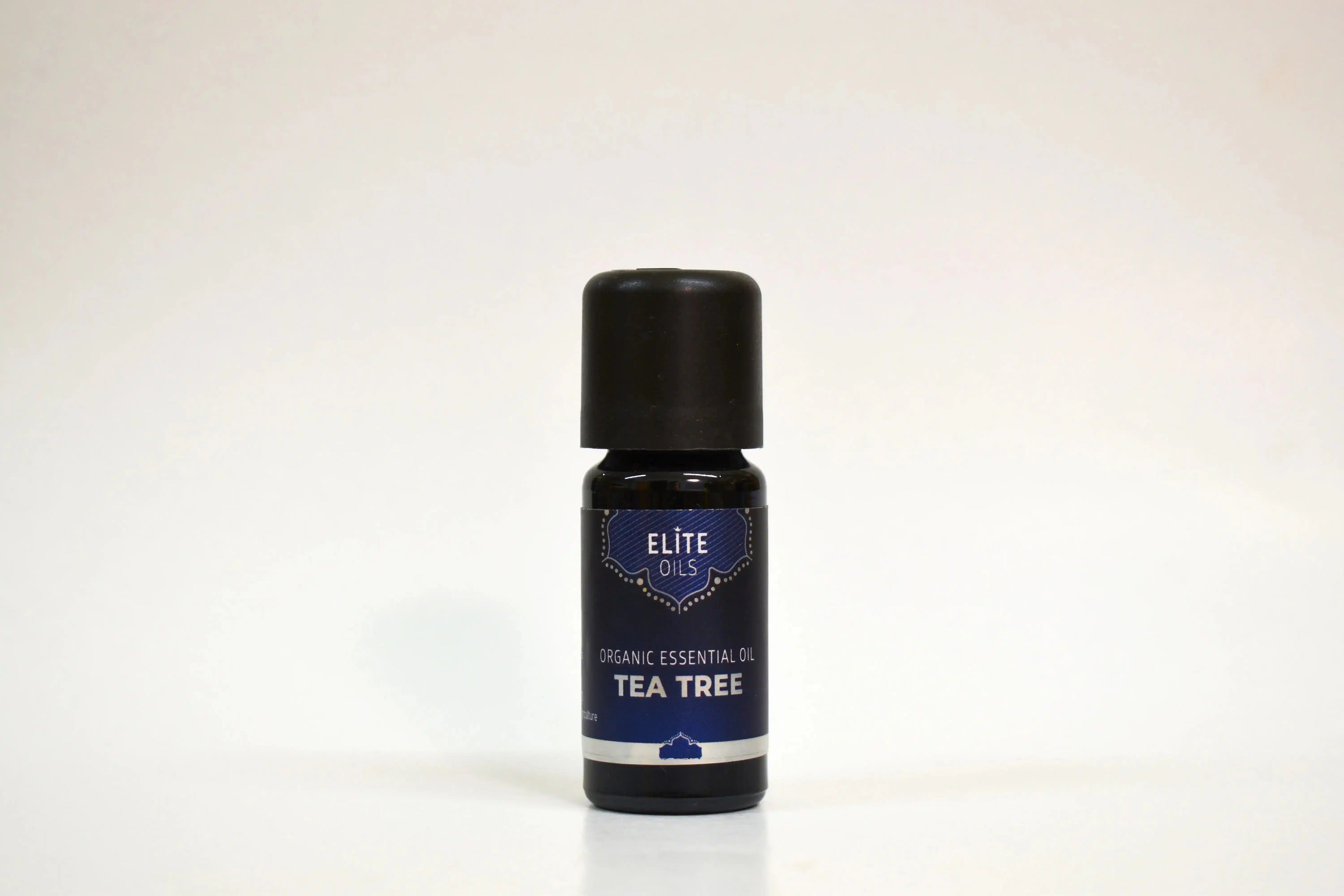 Bottle of Elite Oils Tea Tree essential oil on a white background