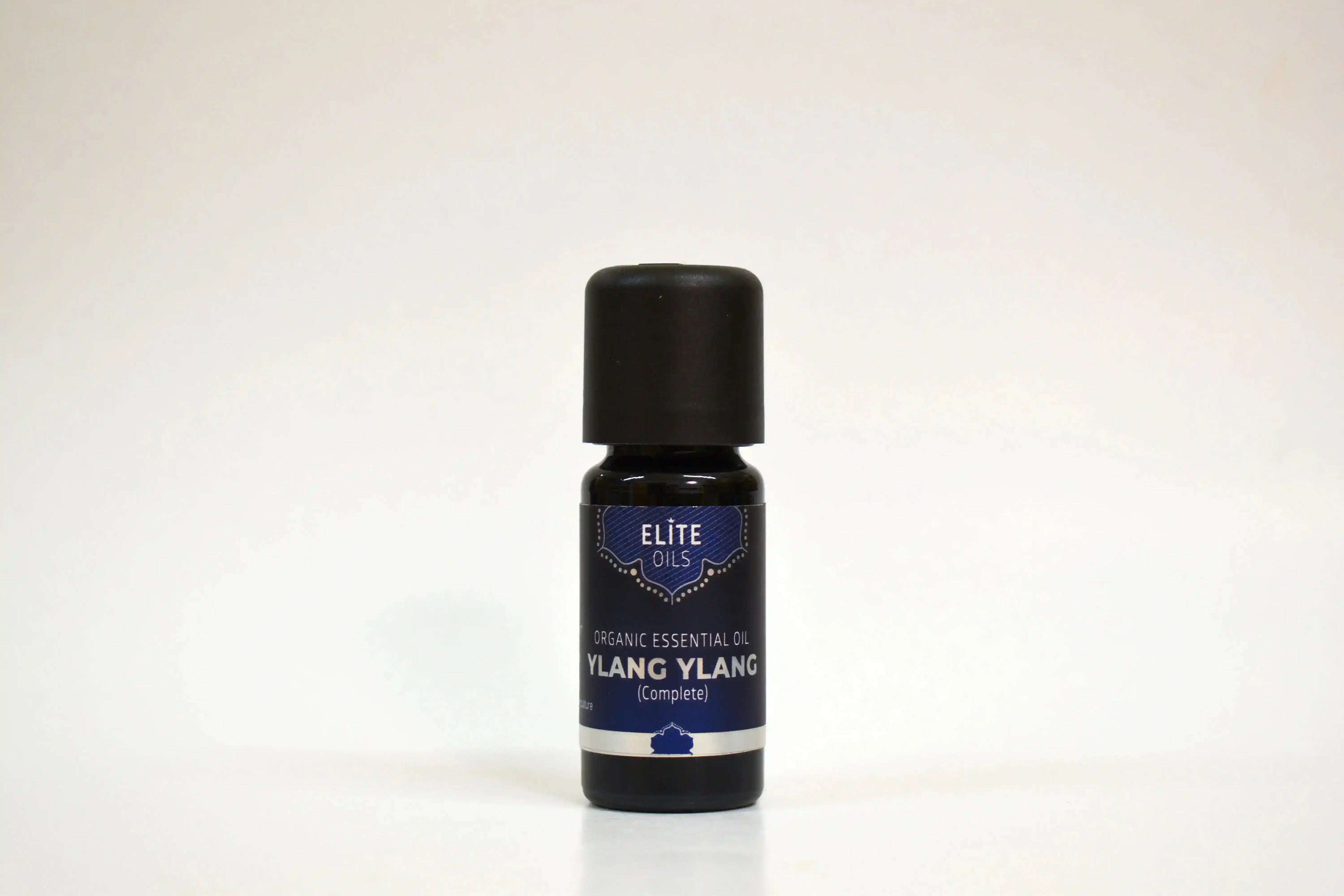 Botella de aceite esencial de Ylang Ylang sobre fondo blanco