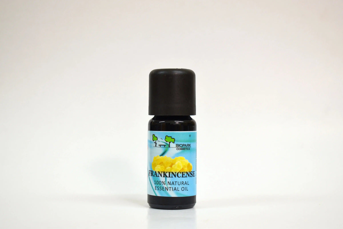 Botella de aceite esencial etiquetada como 'Frankincense' sobre fondo blanco