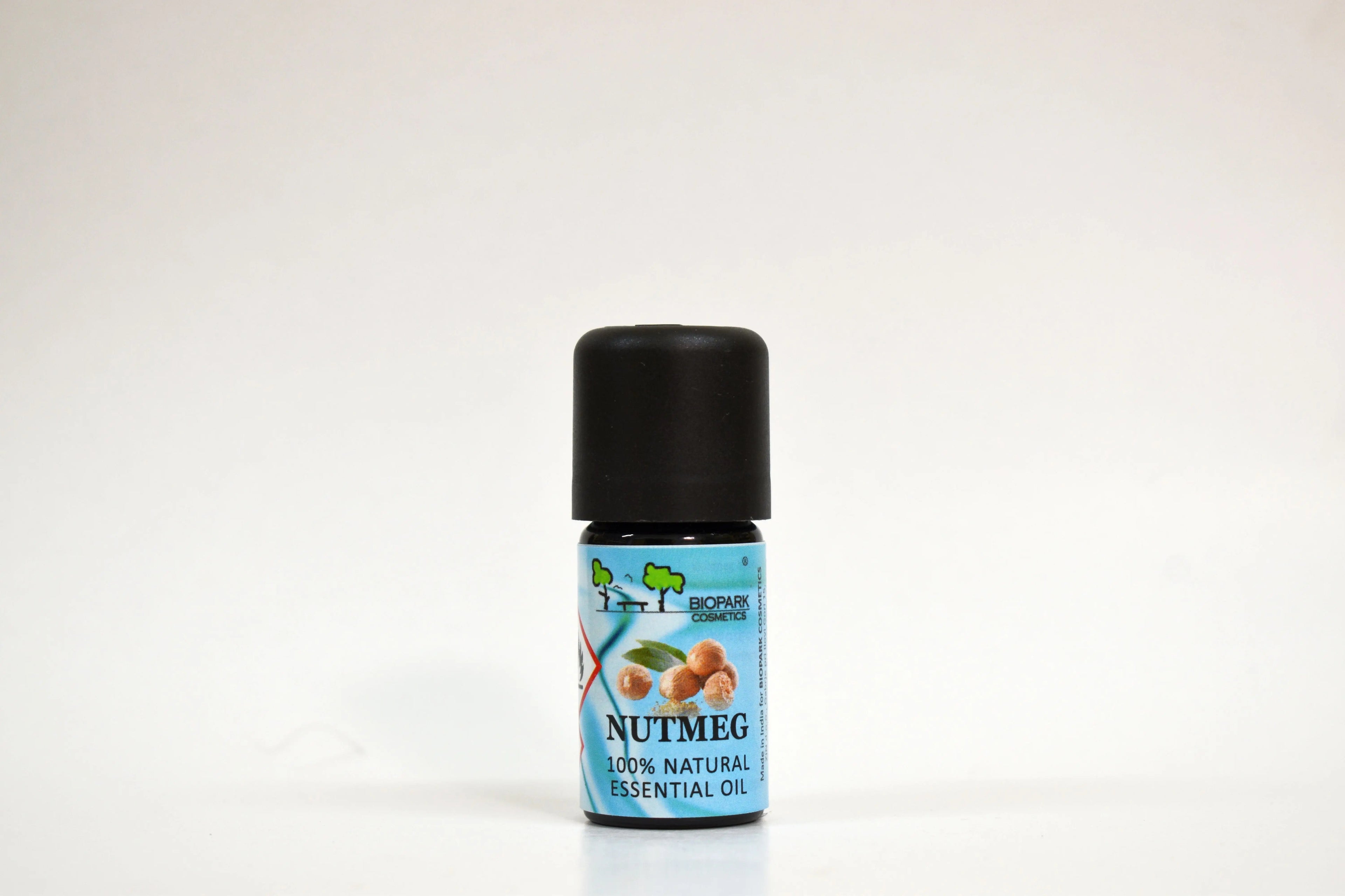 Bottle of Nutmeg essential oil on a white background