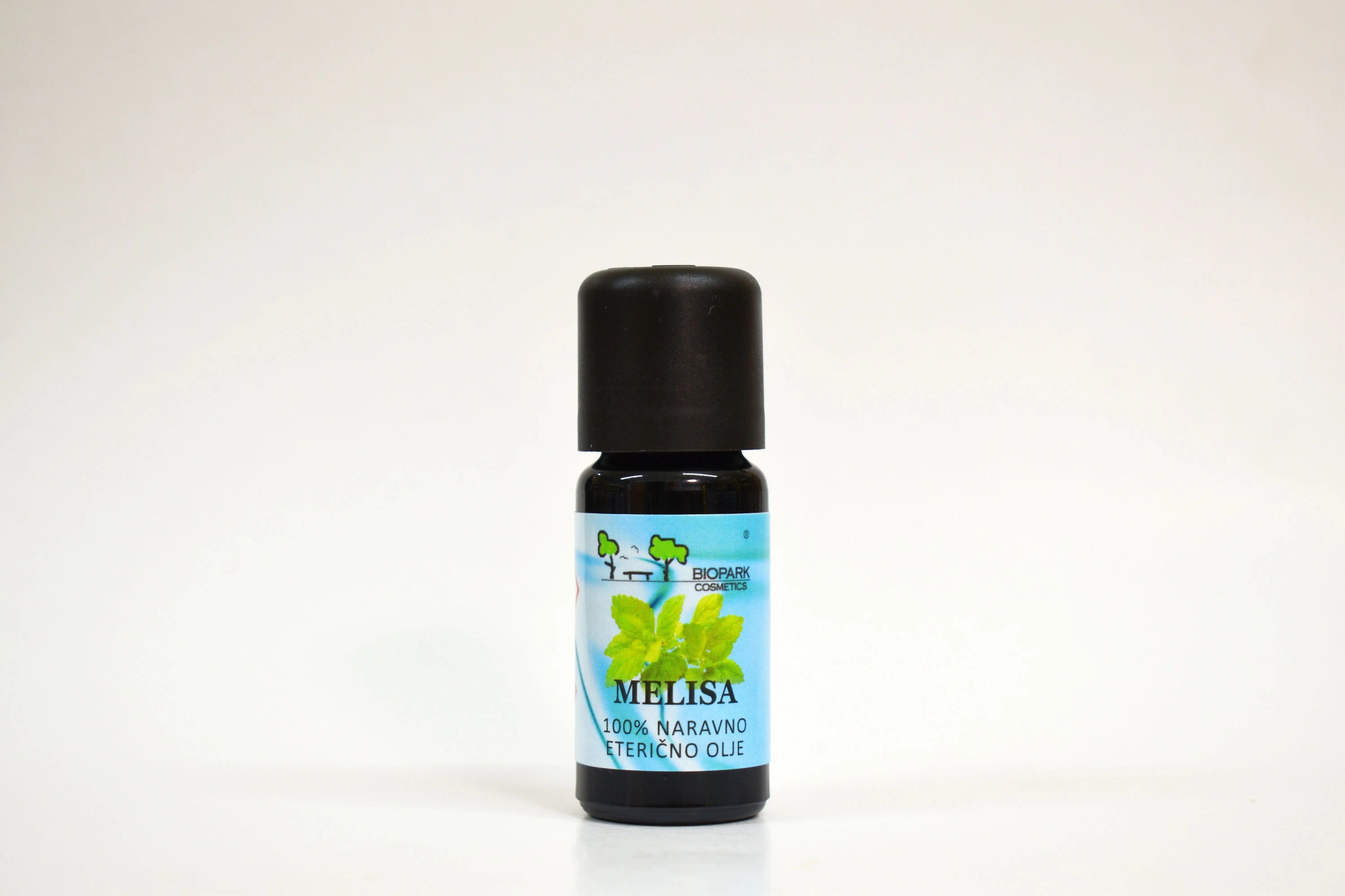 Bottle of Melissa essential oil with a black cap on a white background