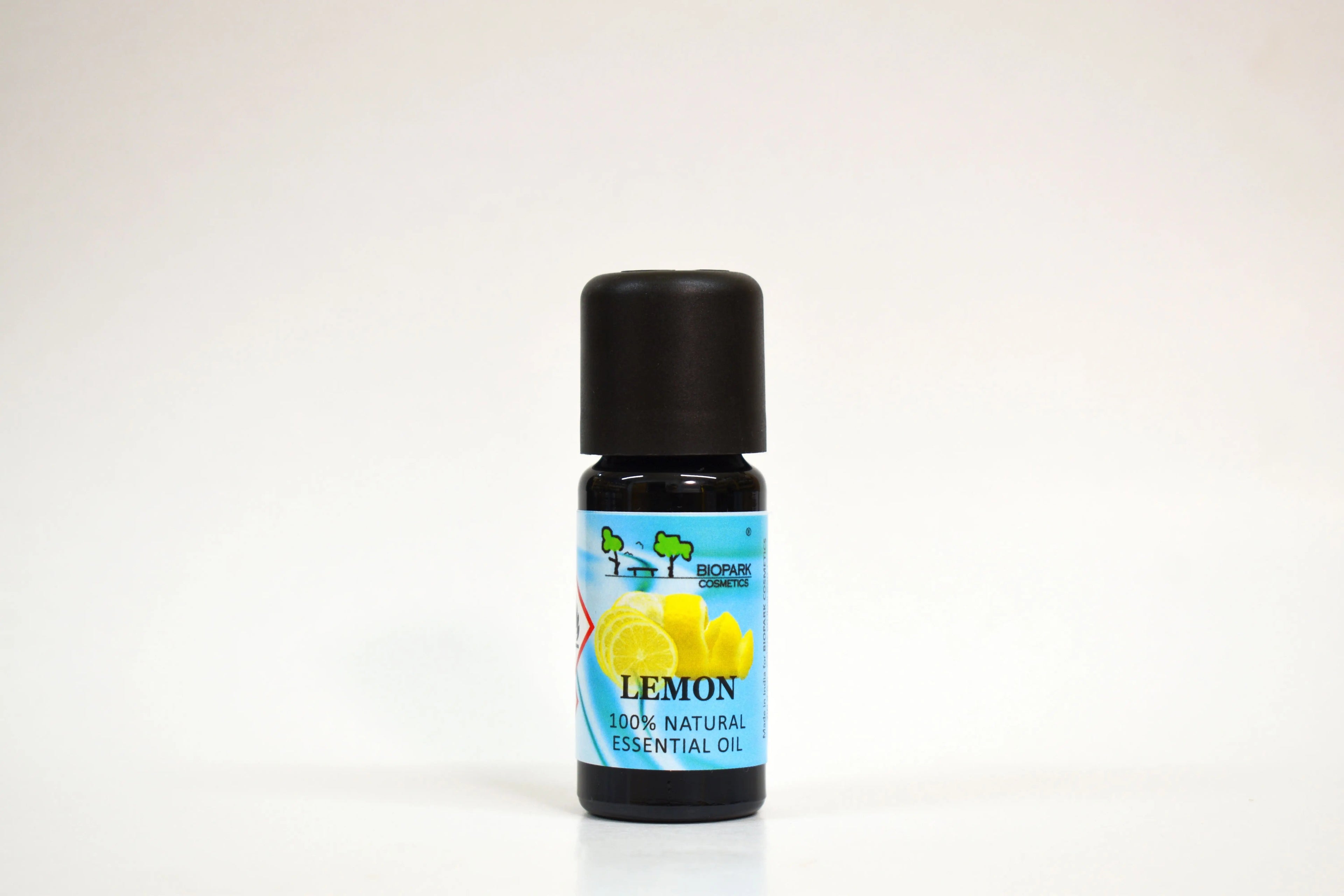 Bottle of lemon essential oil with a black cap on a white background