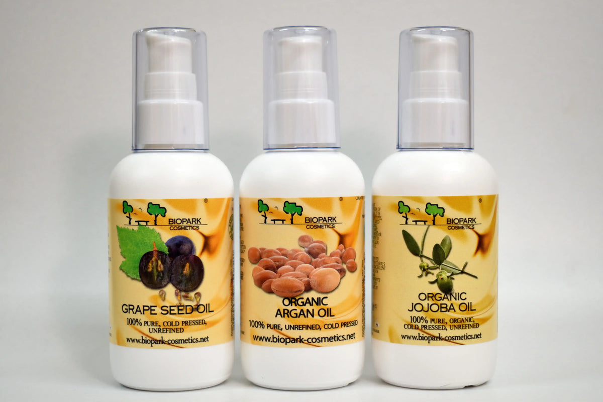 Three bottles of organic oils with visible labels on a gray background
