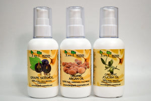 Three bottles of organic oils with visible labels on a gray background