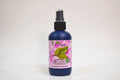 Bottle of organic bay leaf hydrosol with a pink label on a white background