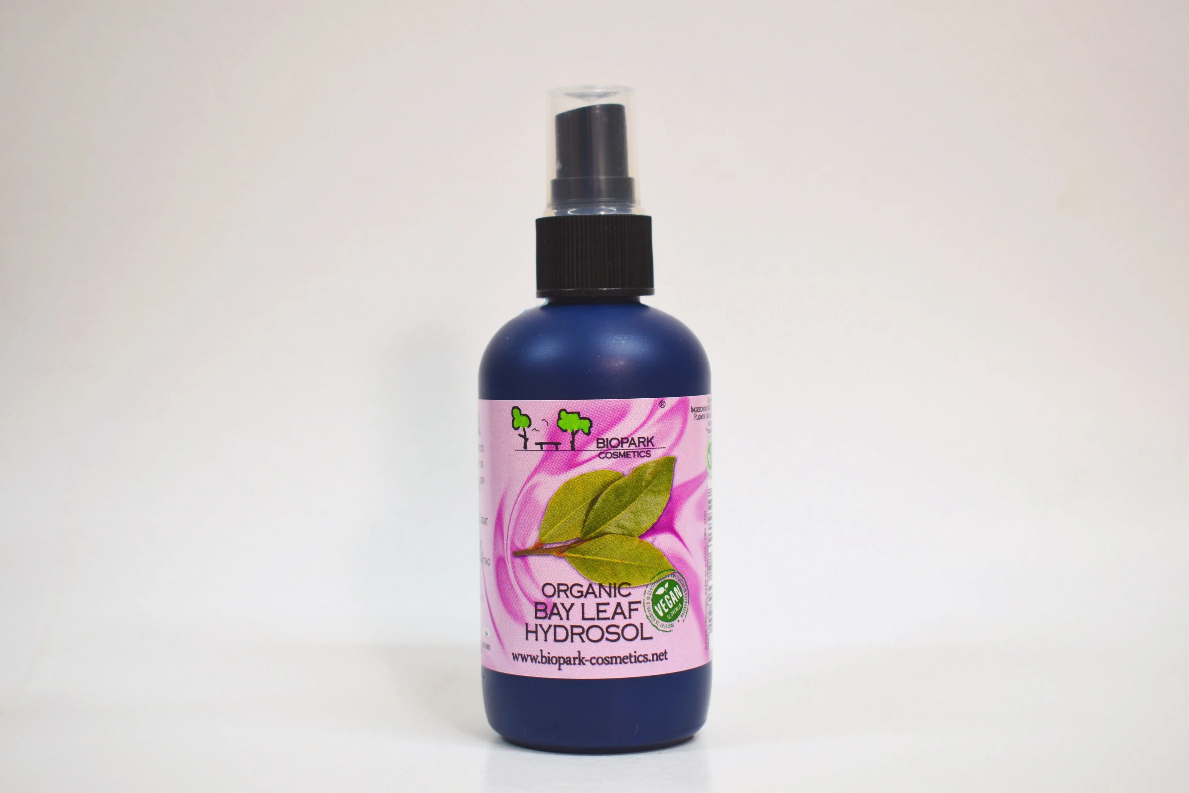 Bottle of organic bay leaf hydrosol with a pink label on a white background