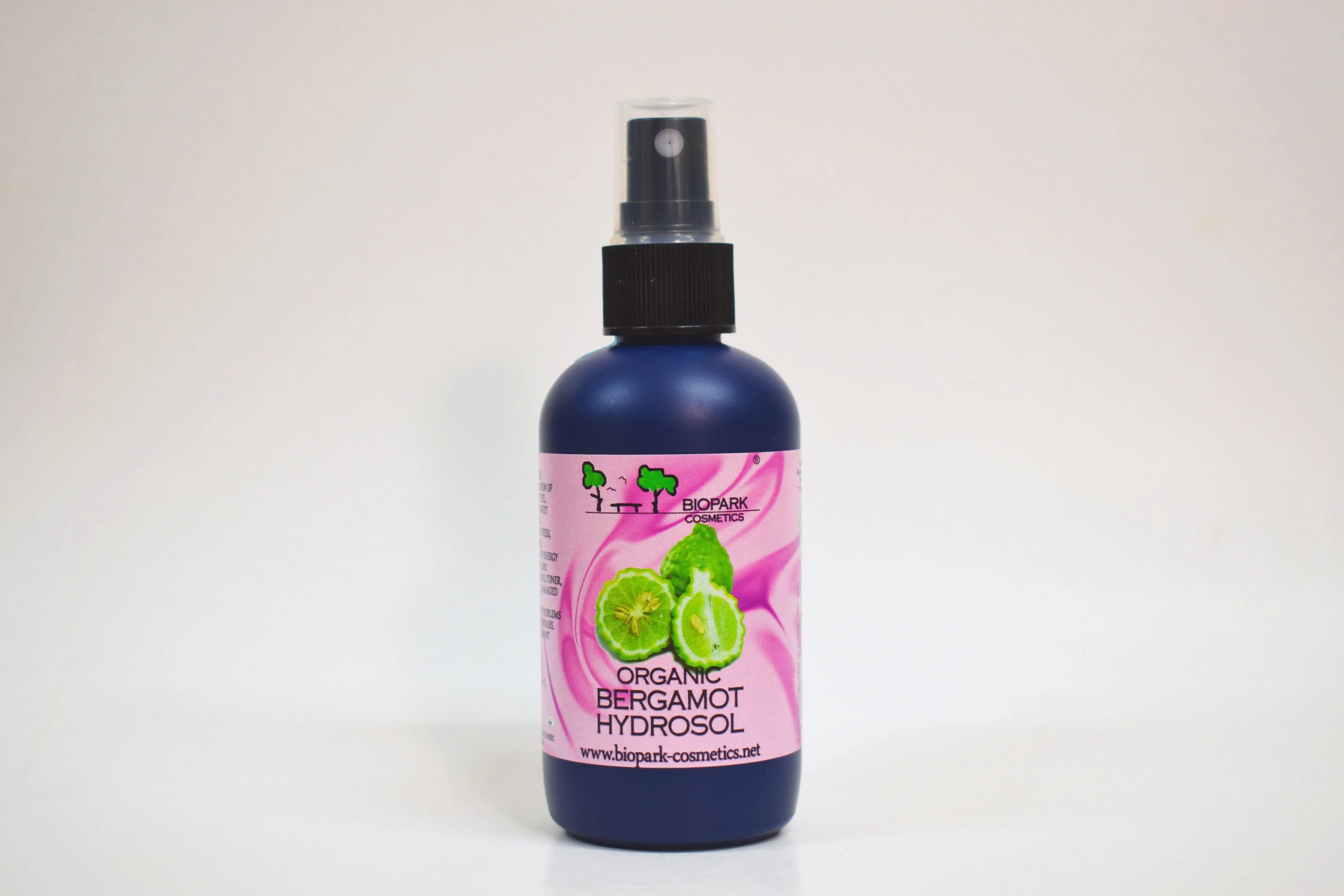 Bottle of organic bergamot hydrosol with a pink label on a white background