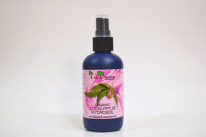 Bottle of organic eucalyptus hydrosol with a pink label on a white background