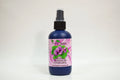 Bottle of organic geranium hydrosol with a pink label on a white background