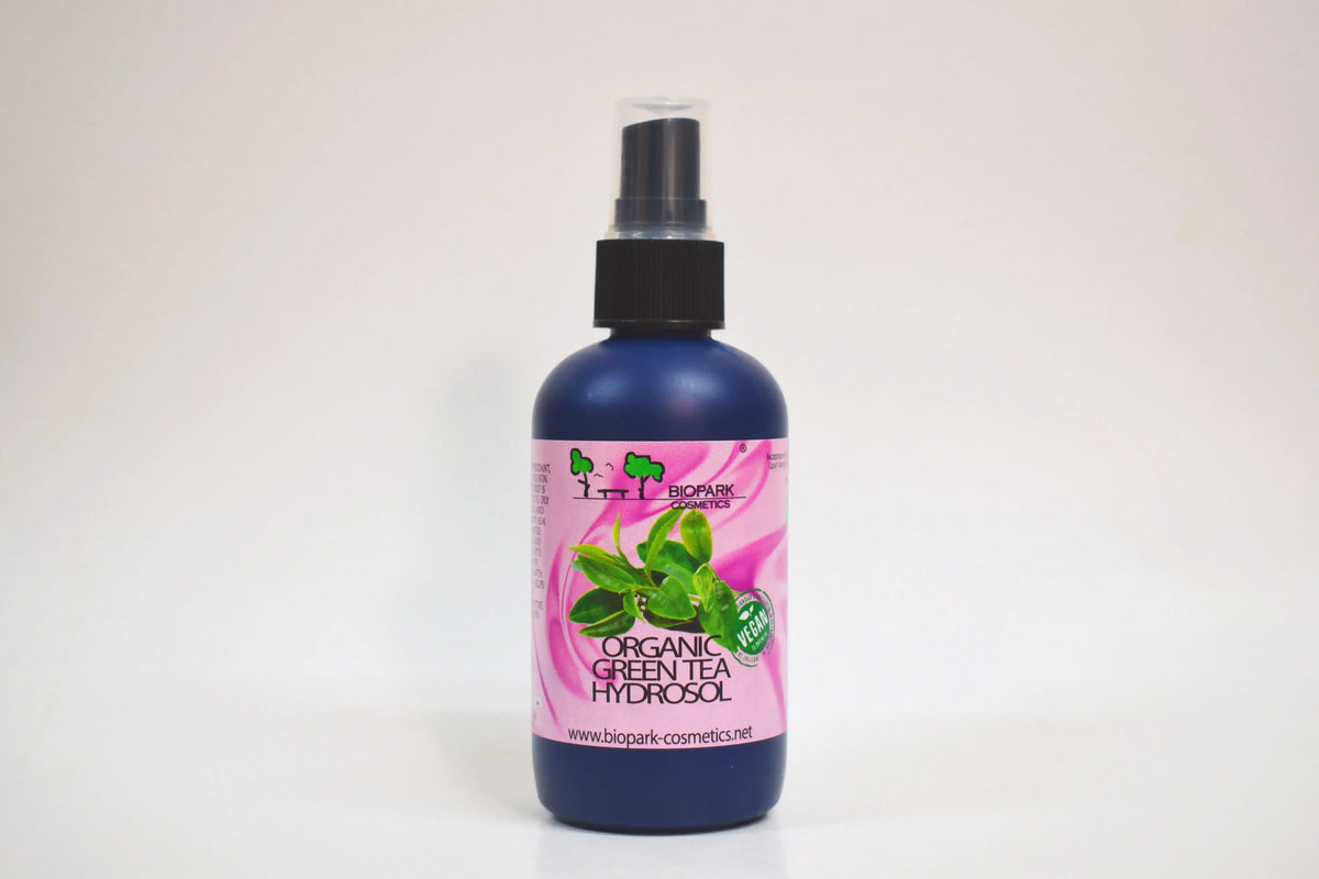 Bottle of organic green tea hydrosol with a pink label on a white background