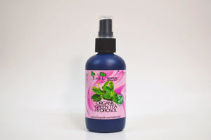 Bottle of organic green tea hydrosol with a pink label on a white background