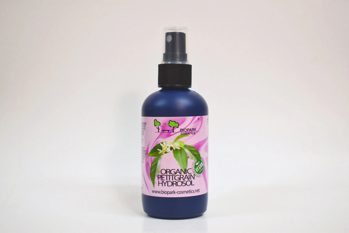 Bottle of organic facial toner with a pink label on a white background