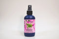 Bottle of organic rosemary hydrosol with a pink label on a white background