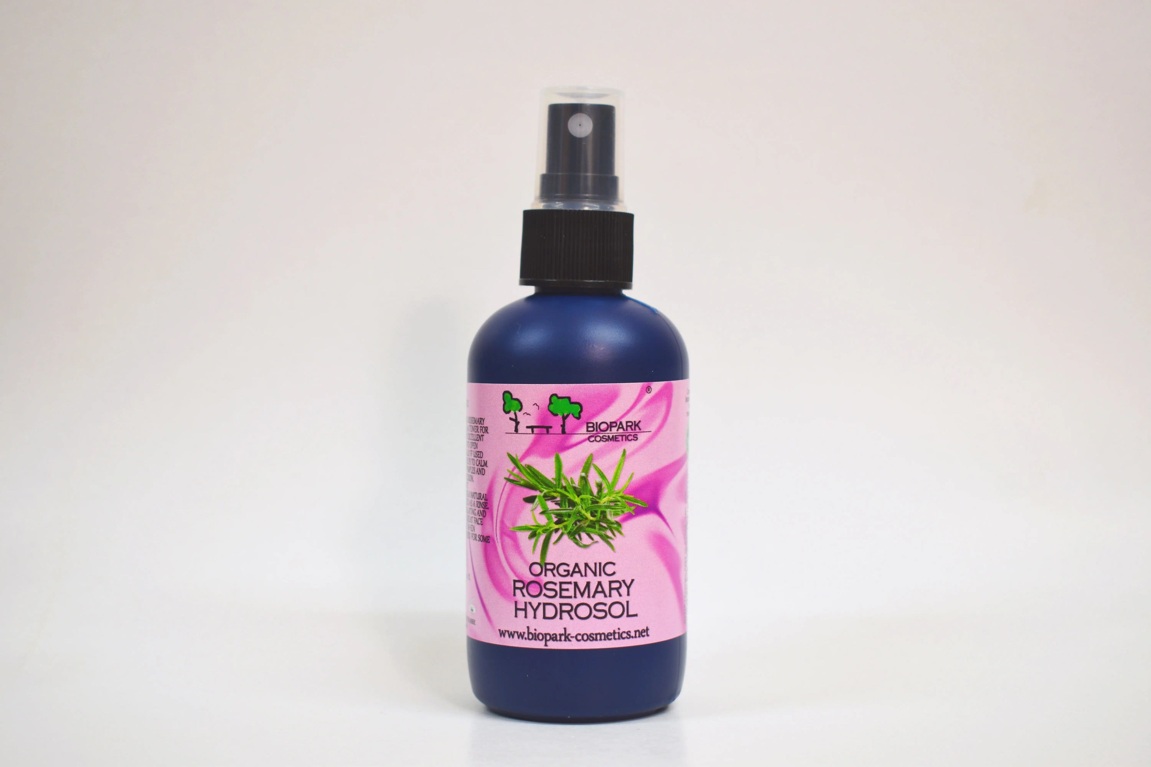 Bottle of organic rosemary hydrosol with a pink label on a white background