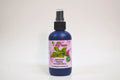 Bottle of organic sage hydrosol with a pink label on a white background