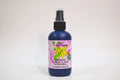 Bottle of organic ylang ylang hydrosol with a pink label on a white background