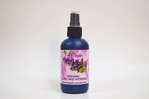 Bottle of organic clary sage hydrosol with a floral label on a white background