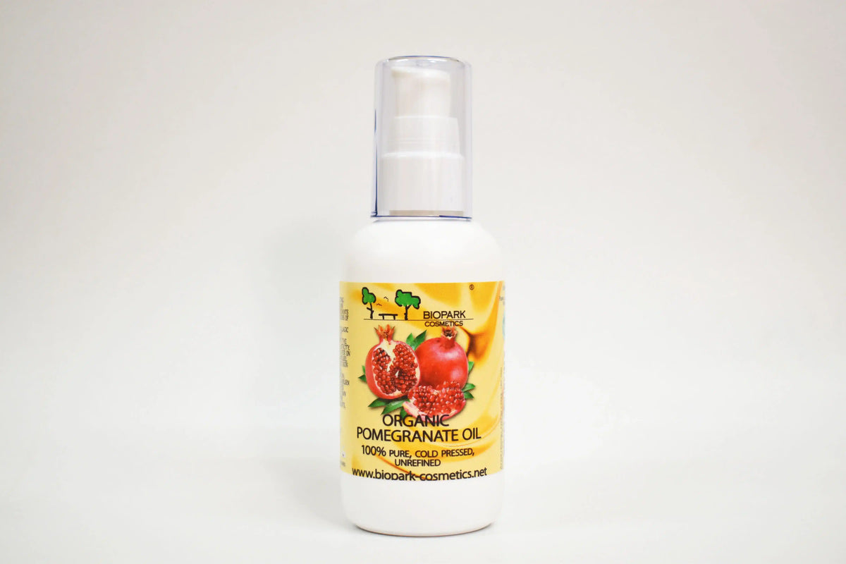 Bottle of organic pomegranate oil with a yellow label on a white background