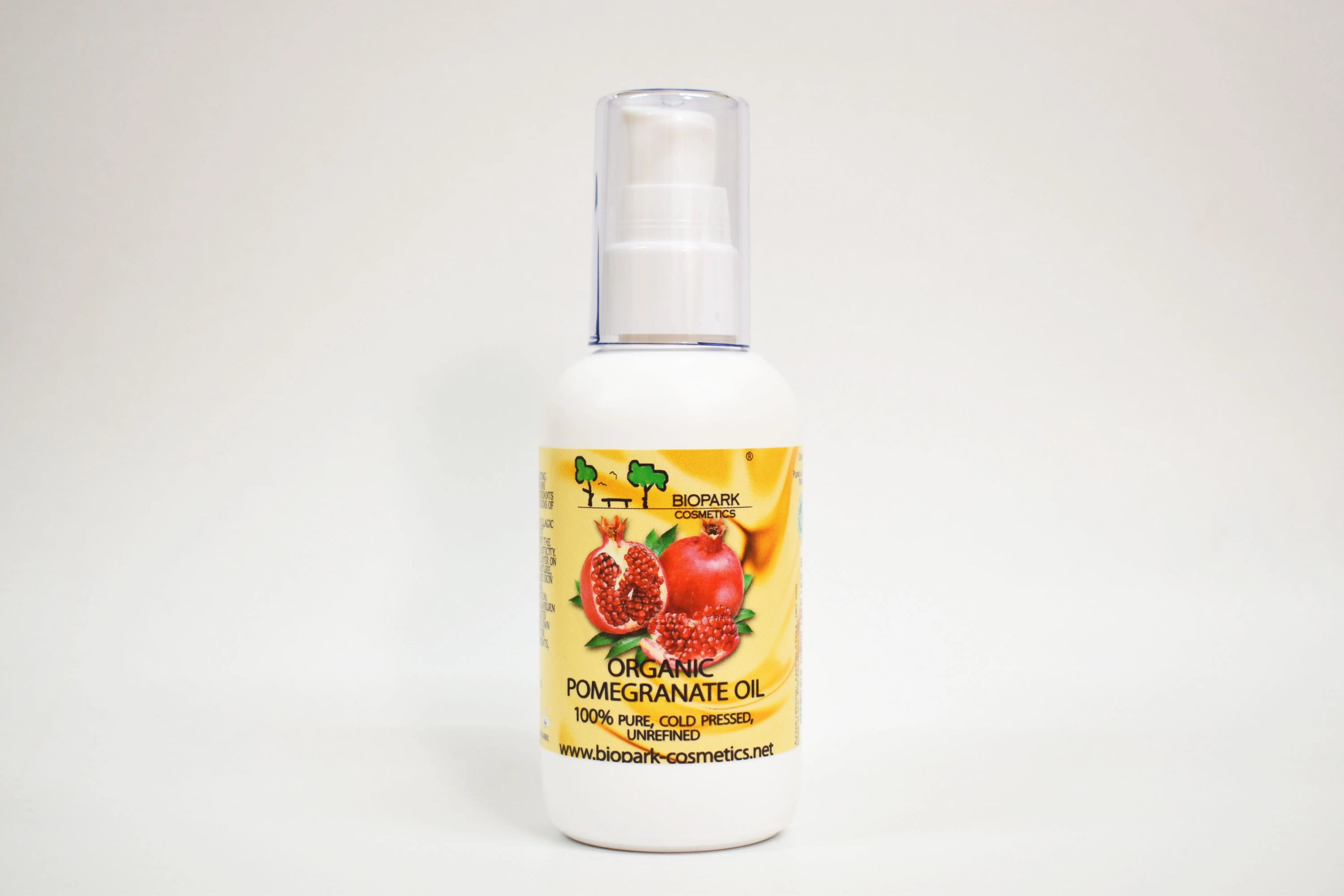 Bottle of organic pomegranate oil with a yellow label on a white background