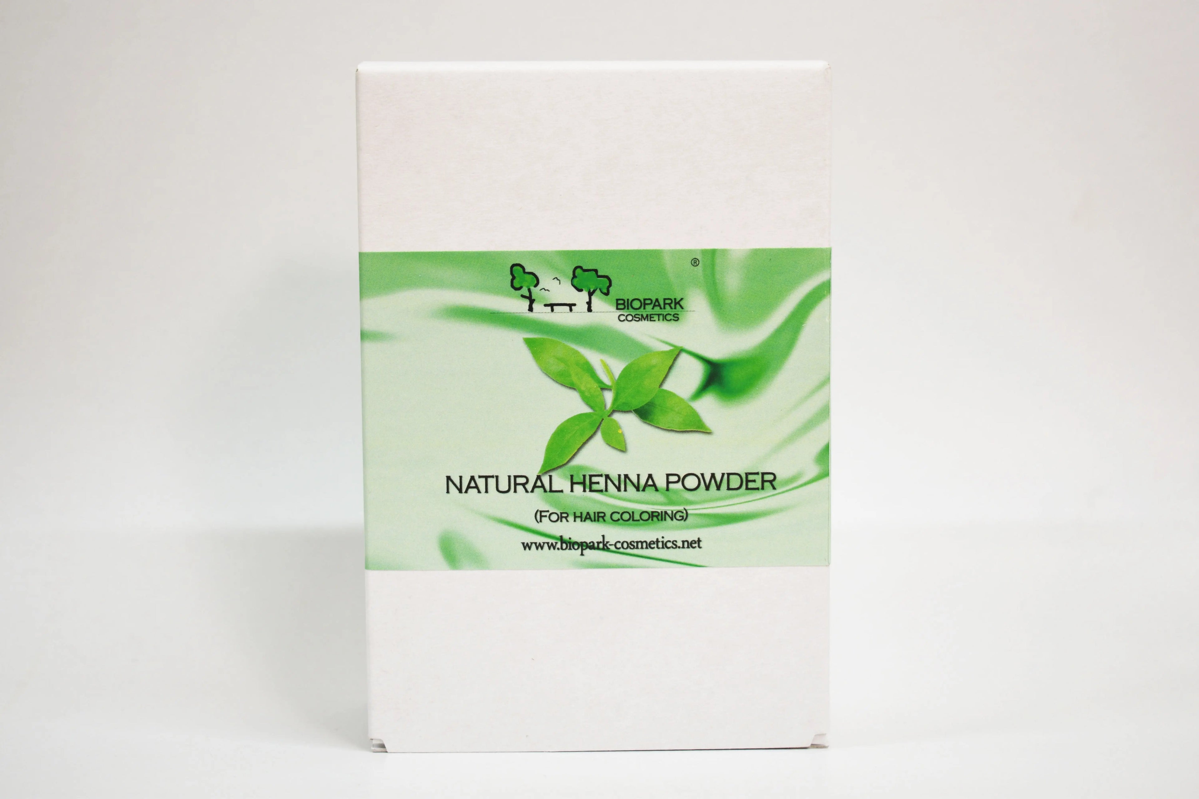 Box of natural henna powder with green leaf design on a white background