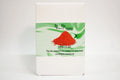 Box of red clay product with green label on a white background