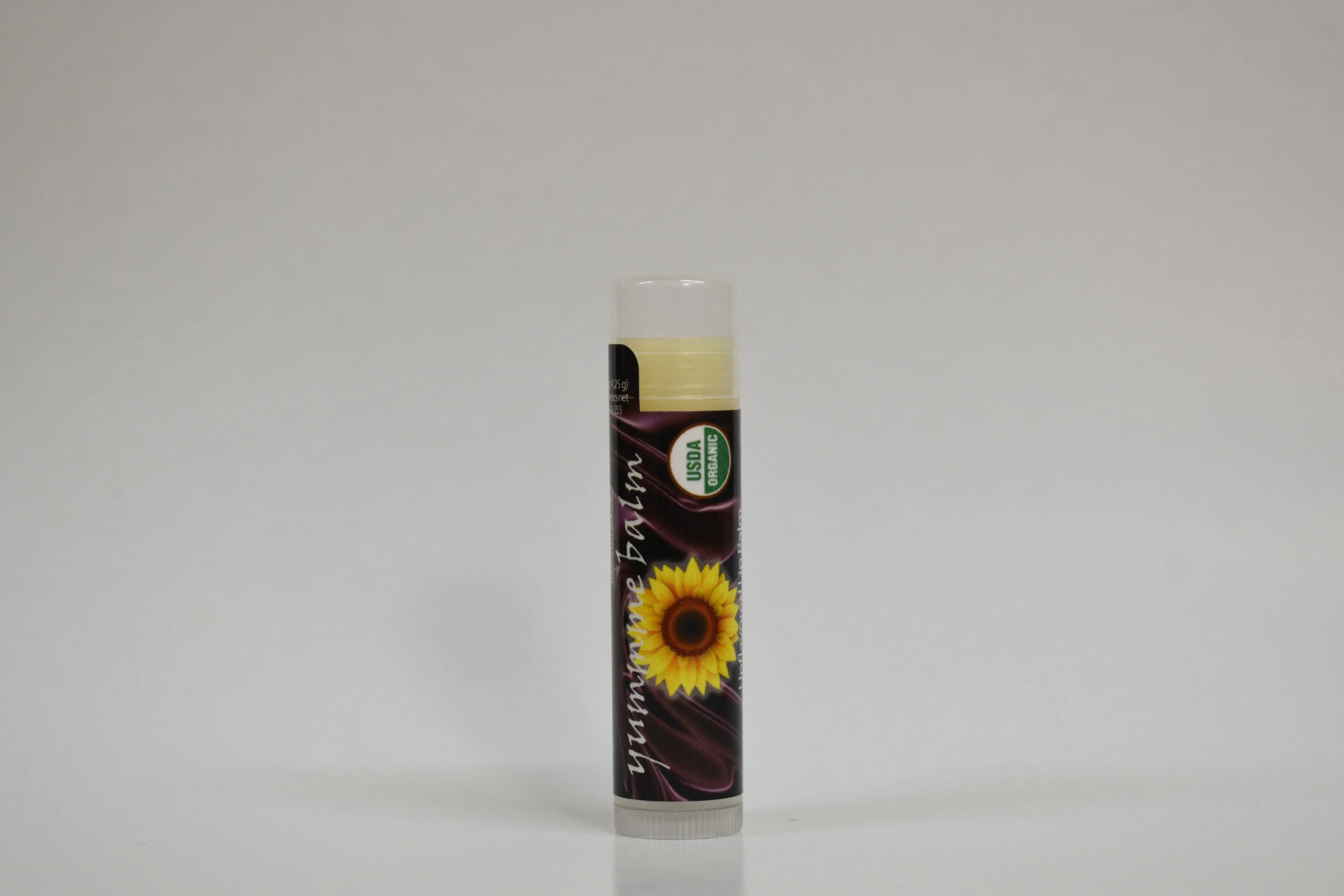 Lip balm with sunflower design on a gray background