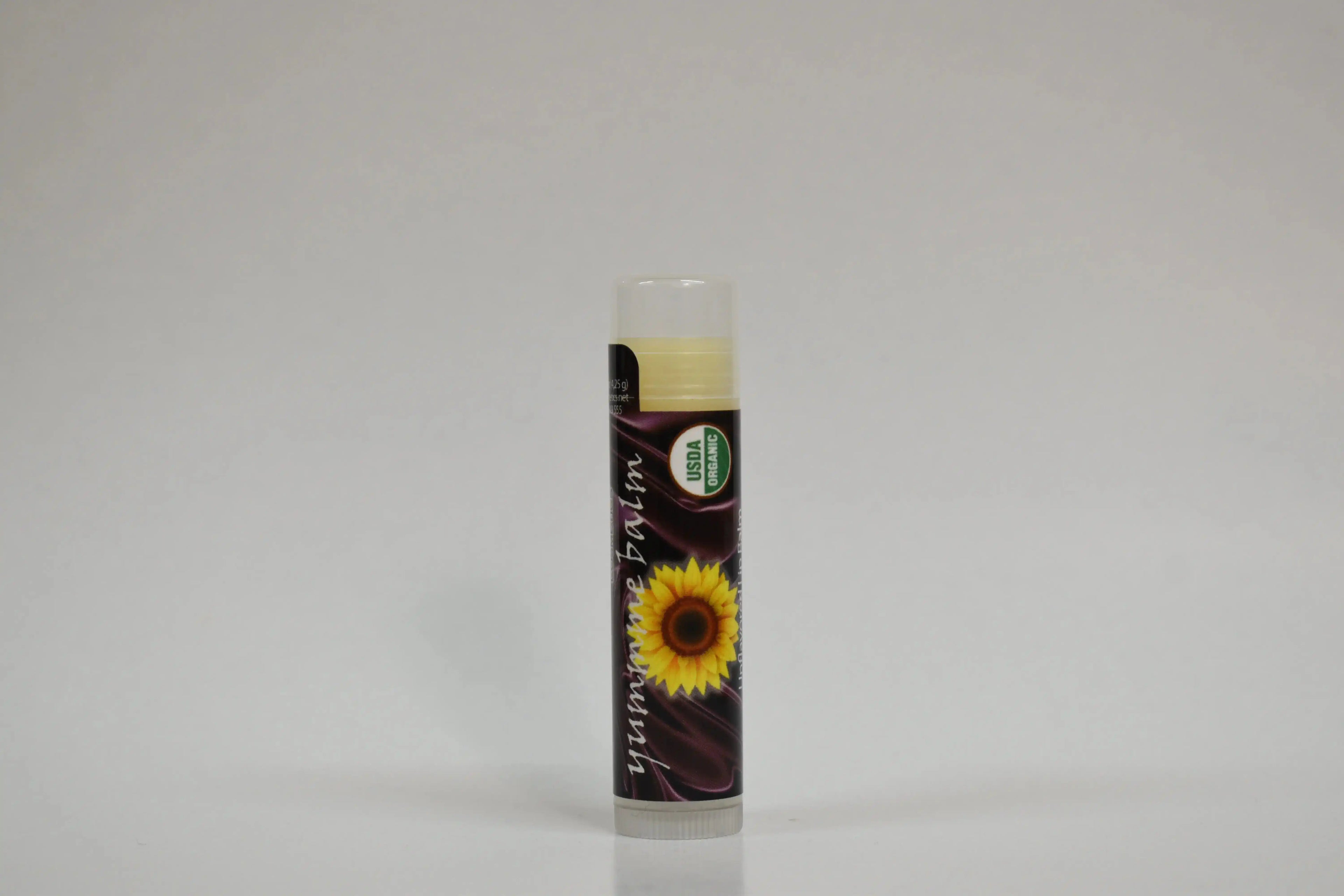 Lip balm with sunflower design on a gray background