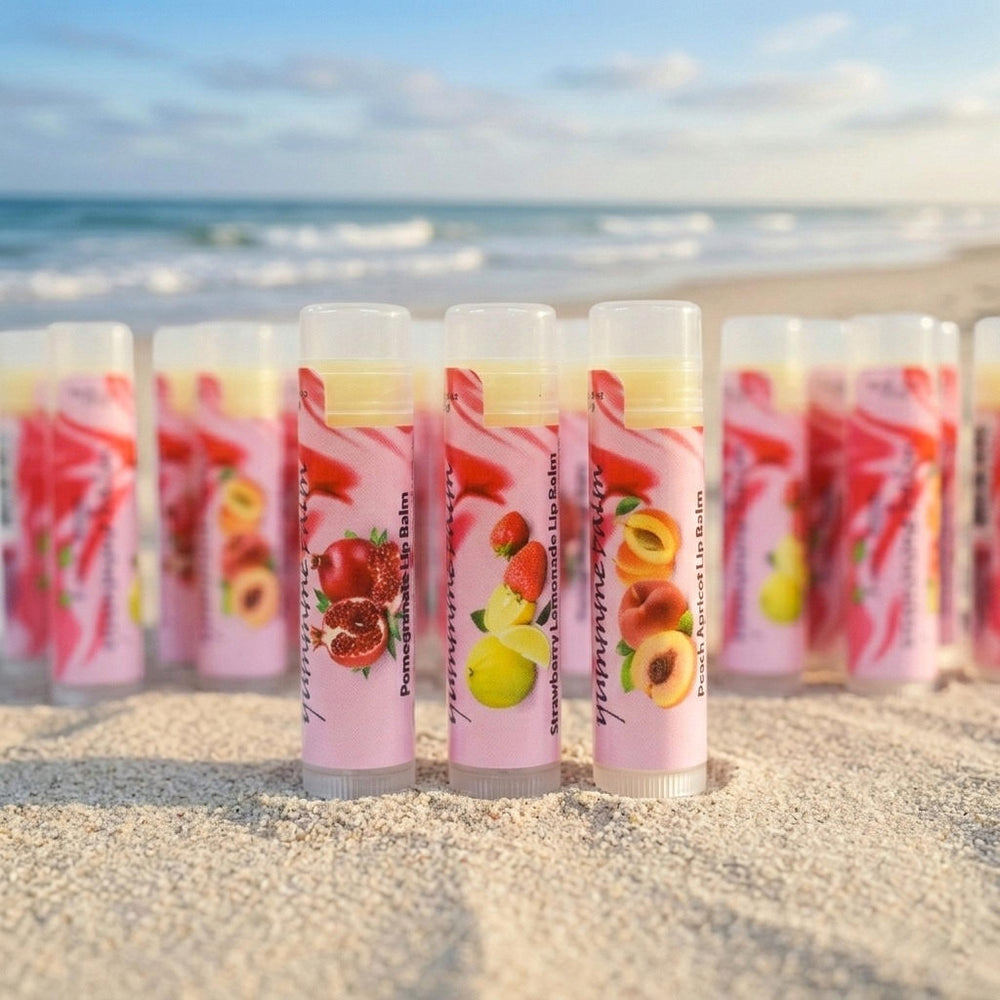 Lip balm tubes with fruit illustrations on a sandy beach